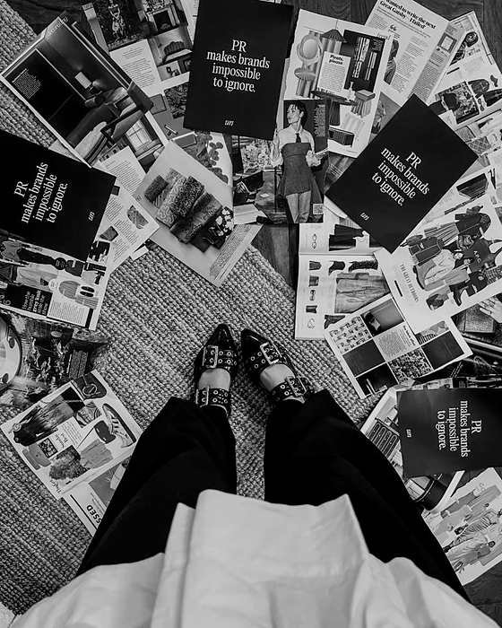 Press cards and open magazine spreads arranged on the floor